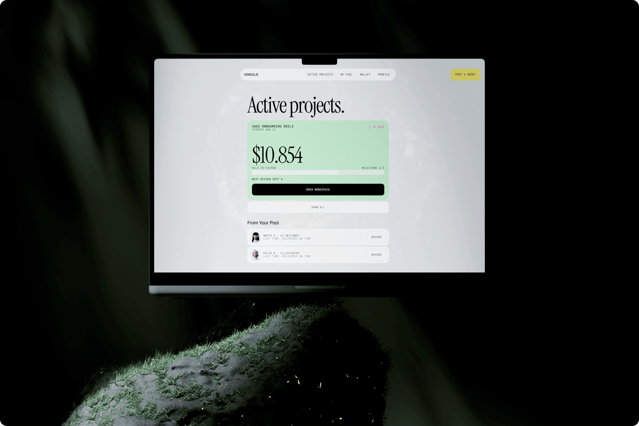 Vinculo Active projects screen on a laptop resting on a mossy stone